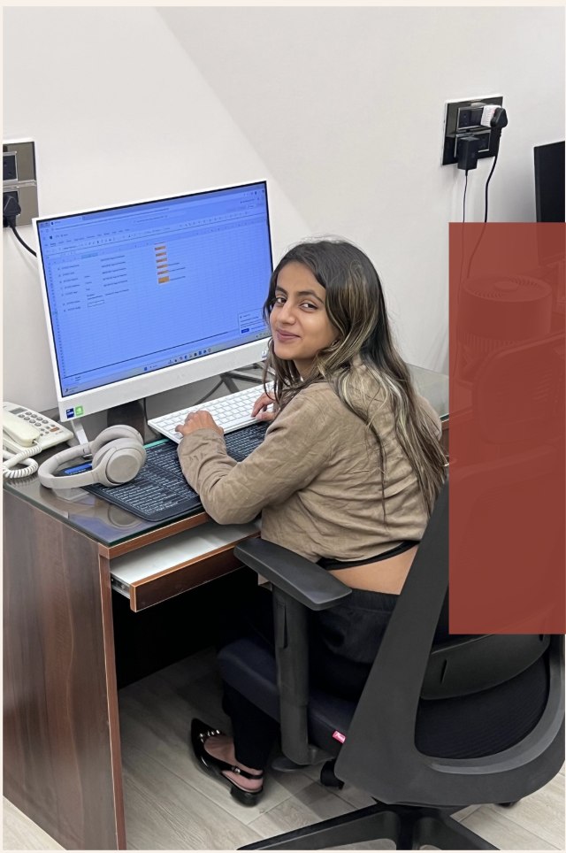 Ameesha at her desk at K2 Fragrances, working on client sales records